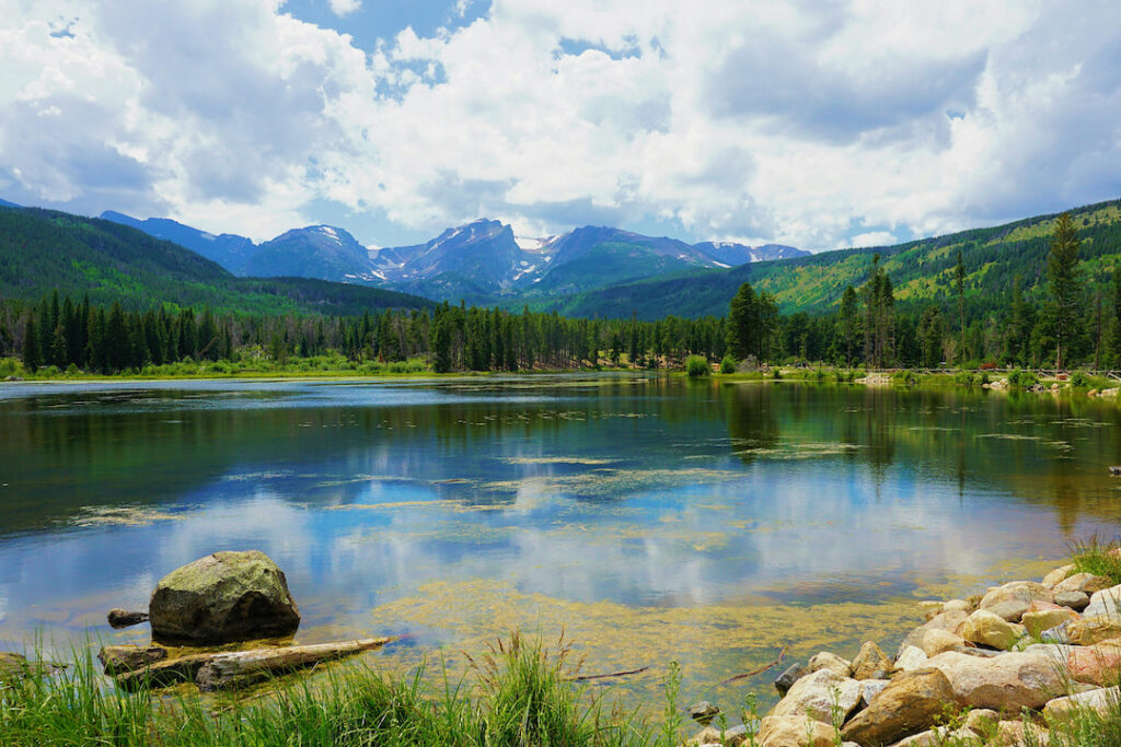 Alpine lake reflecting Rocky Mountain peaks.