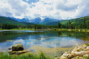 Alpine lake reflecting Rocky Mountain peaks.