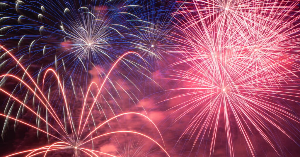 Colorful fireworks illuminating the night sky during a Fourth of July celebration.